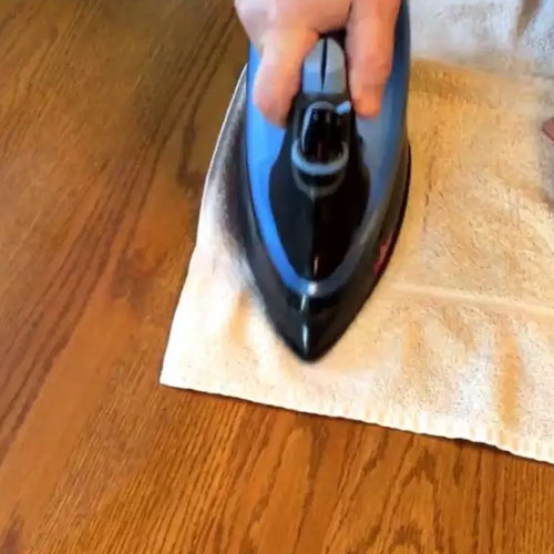 استفاده از اتوی بخار برای از بین بردن لکه روی میز چوبی 